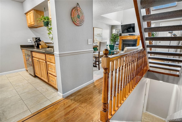 5155 W 68th Ave Unit 5, Westminster, CO 80030 - stairway featuring baseboards, a fireplace, a textured wall, and tile patterned floors