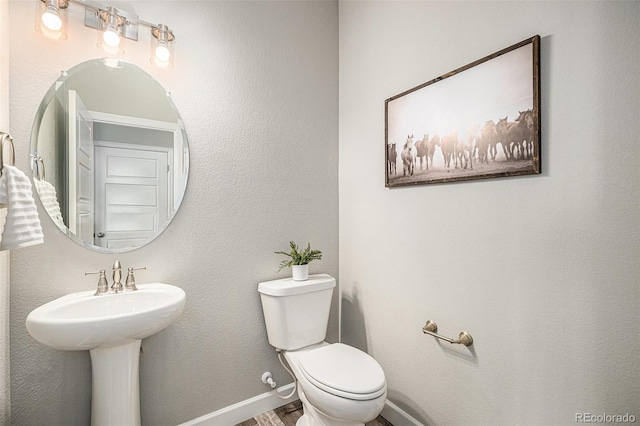 1011 White Leaf Cir, Castle Rock, CO 80108 - half bath featuring toilet, wood finished floors, baseboards, and a sink