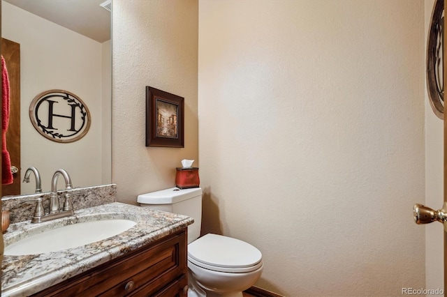 7354 S Robb St, Littleton, CO 80127 - half bath with vanity, toilet, and a textured wall