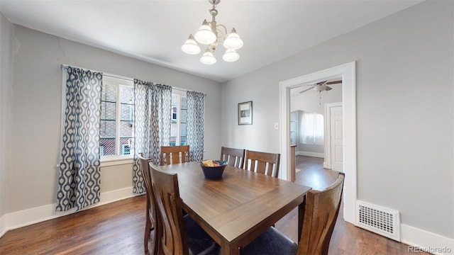 dining room with ceiling fan with notable chandelier and dark hardwood / wood-style floors