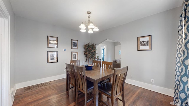 dining room featuring a notable chandelier and dark wood-type flooring