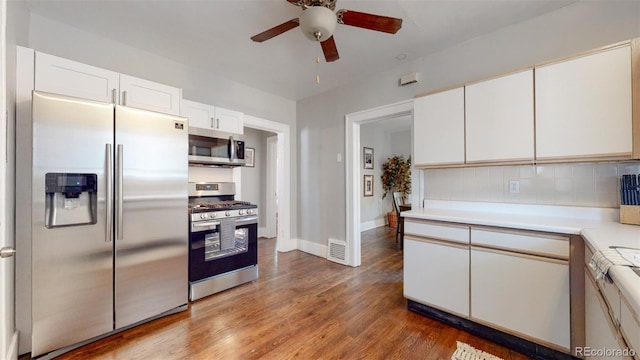 kitchen featuring ceiling fan, backsplash, appliances with stainless steel finishes, white cabinets, and light wood-type flooring