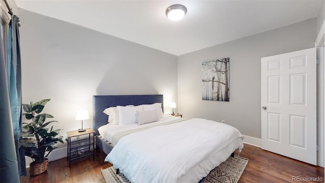 bedroom with dark wood-type flooring