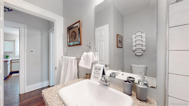 bathroom with hardwood / wood-style flooring, toilet, and sink