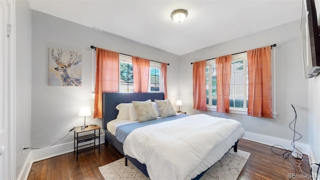 bedroom with dark hardwood / wood-style flooring