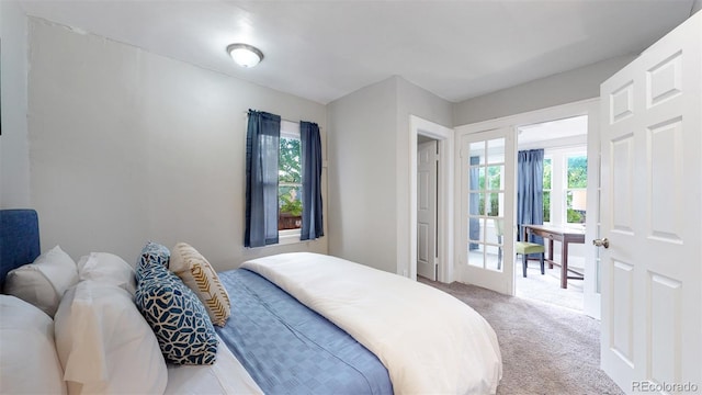 bedroom with multiple windows, french doors, and carpet floors