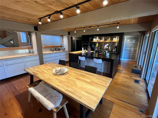 24226 Currant Dr, Golden, CO 80401 - dining area with track lighting, light wood-style flooring, and wooden ceiling