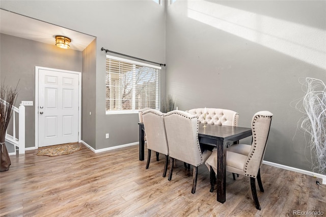 dining space featuring baseboards and wood finished floors