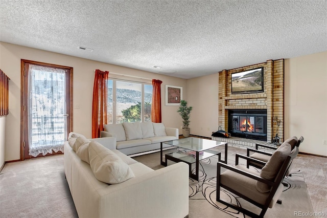 carpeted living room featuring a brick fireplace and a textured ceiling