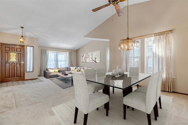 dining space with a notable chandelier, high vaulted ceiling, and light carpet