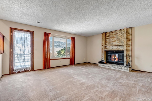 unfurnished living room with a textured ceiling, light colored carpet, and a fireplace