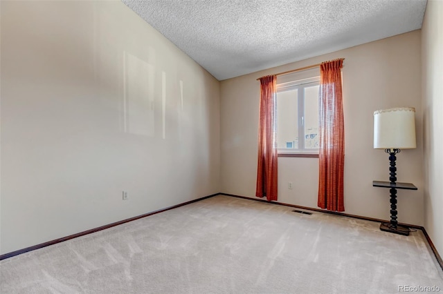 carpeted spare room with a textured ceiling