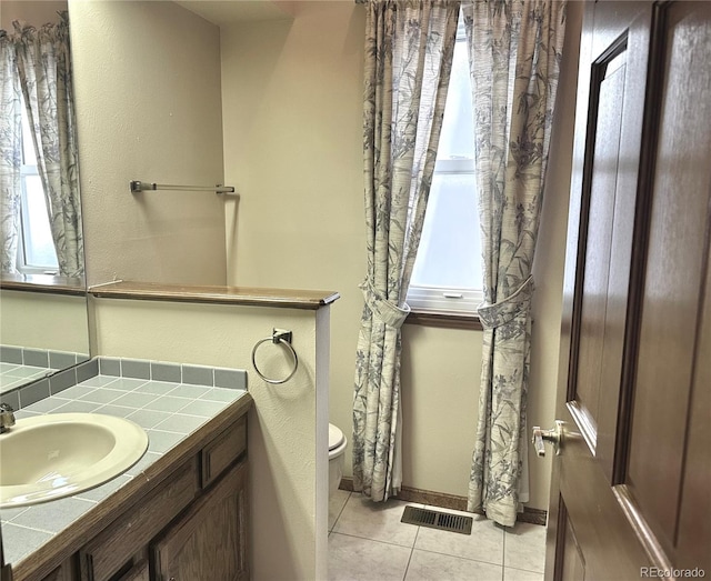 bathroom featuring tile patterned floors, vanity, and toilet