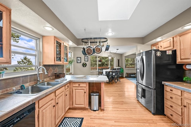 13540 Deer Ridge Way, Larkspur, CO 80118 - kitchen featuring a peninsula, freestanding refrigerator, light brown cabinetry, black dishwasher, and light wood-type flooring
