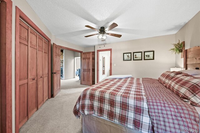 13540 Deer Ridge Way, Larkspur, CO 80118 - bedroom featuring light carpet, a closet, a textured ceiling, and a ceiling fan