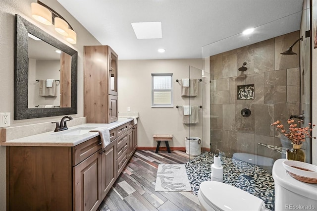 13540 Deer Ridge Way, Larkspur, CO 80118 - bathroom featuring a skylight, vanity, a tile shower, wood finished floors, and recessed lighting