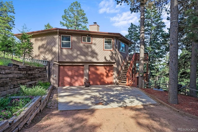 13540 Deer Ridge Way, Larkspur, CO 80118 - view of front of property with a chimney, stairway, an attached garage, and driveway