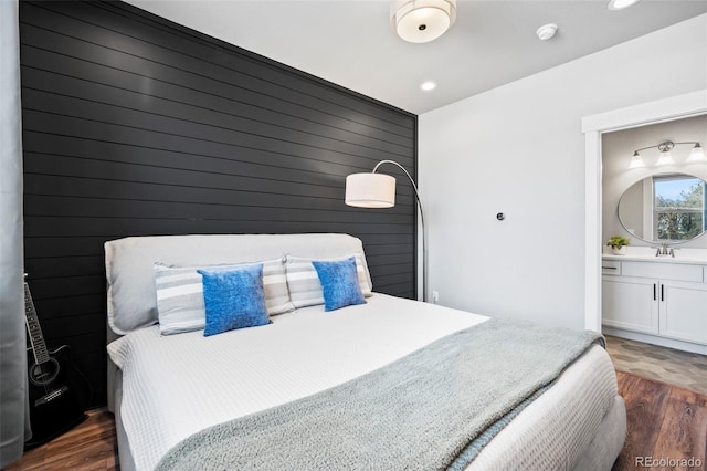 bedroom with sink, connected bathroom, and dark hardwood / wood-style flooring