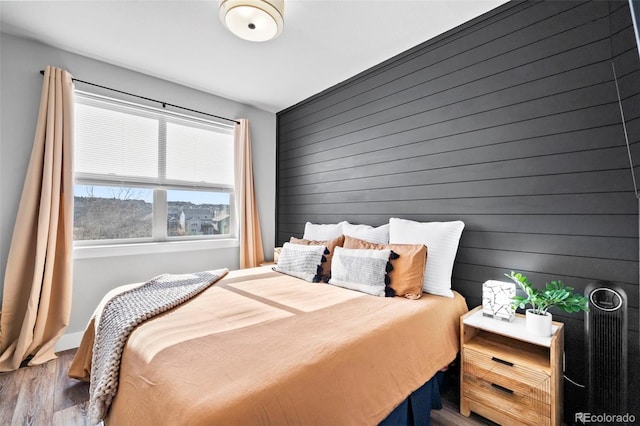 bedroom featuring wood walls and hardwood / wood-style floors