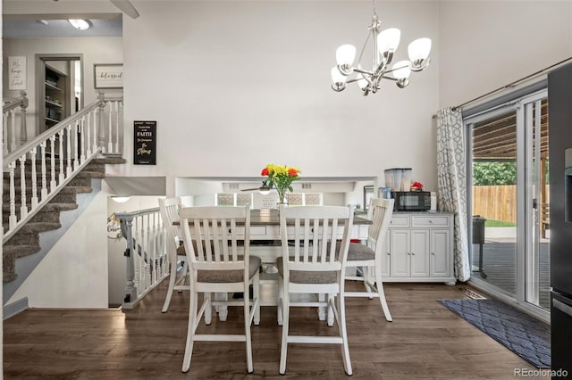 11323 Albion St, Thornton, CO 80233 - dining area featuring a chandelier, wood finished floors, stairs, and a towering ceiling