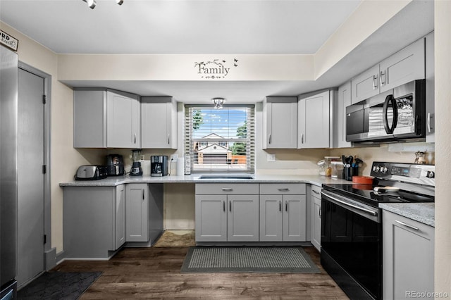 11323 Albion St, Thornton, CO 80233 - kitchen featuring electric range, stainless steel microwave, dark wood finished floors, light countertops, and gray cabinets