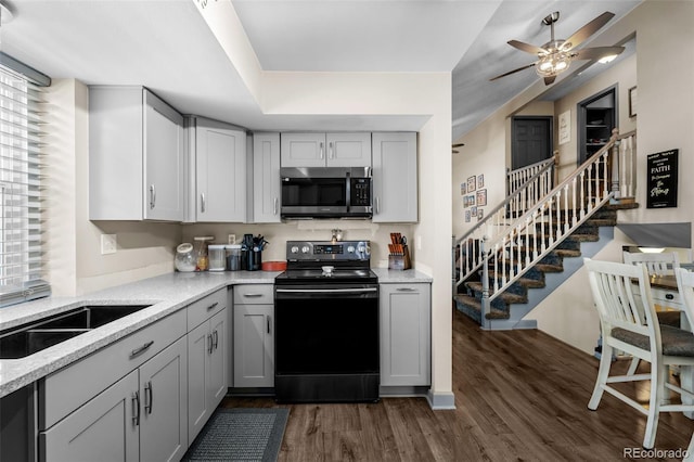 11323 Albion St, Thornton, CO 80233 - kitchen featuring stainless steel microwave, black electric range oven, gray cabinets, a ceiling fan, and healthy amount of natural light