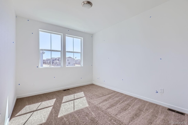 carpeted empty room with baseboards