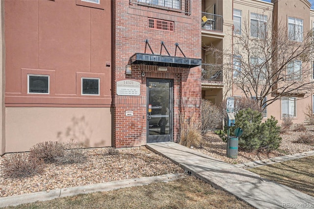 entrance to property featuring brick siding