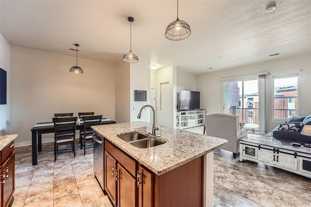 kitchen with a sink, open floor plan, hanging light fixtures, brown cabinets, and dishwasher