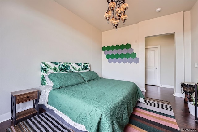 bedroom with an inviting chandelier, baseboards, and wood finished floors