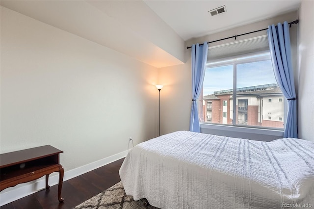 bedroom featuring dark wood-type flooring, visible vents, and baseboards