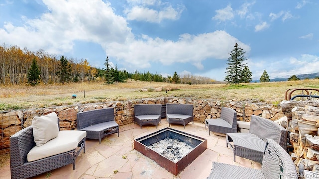 view of patio with an outdoor living space with a fire pit