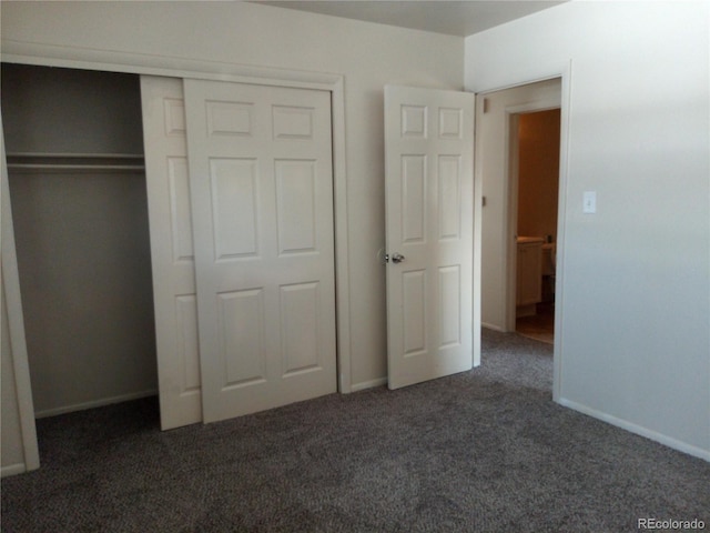 unfurnished bedroom with dark colored carpet and a closet