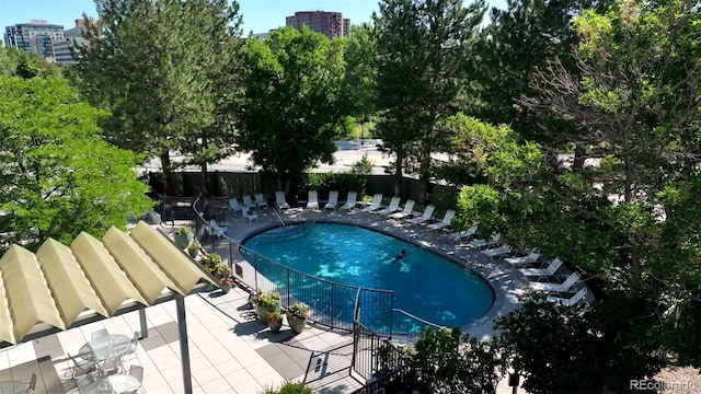 community pool with a view of city and fence