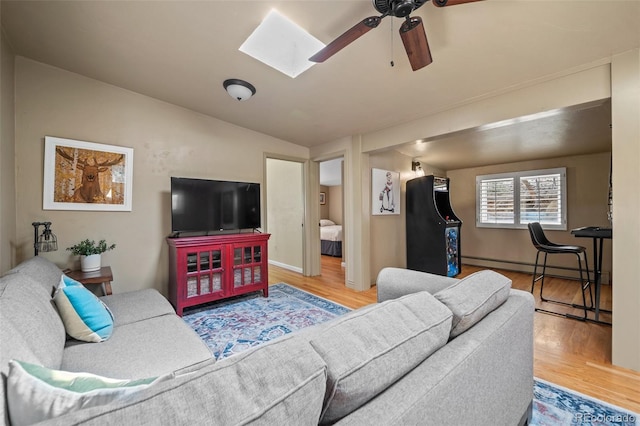 32173 Soda Creek Dr, Evergreen, CO 80439 - living area with a skylight, wood finished floors, ceiling fan, a baseboard heating unit, and lofted ceiling