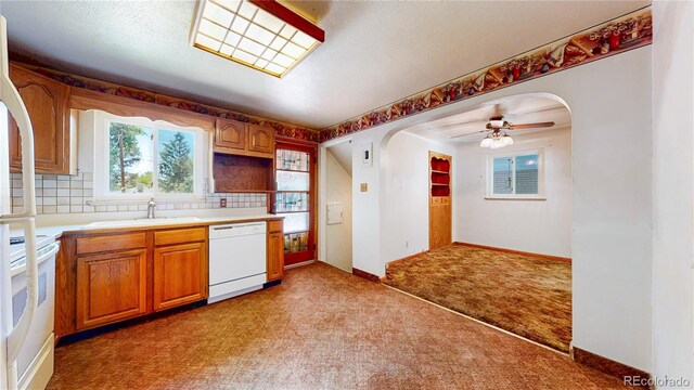 4420 Teller St, Wheat Ridge, CO 80033 - kitchen featuring dishwasher, arched walkways, light colored carpet, range, and light countertops