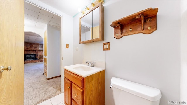 4420 Teller St, Wheat Ridge, CO 80033 - bathroom with vanity, a brick fireplace, and tile patterned flooring