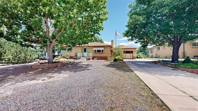 4420 Teller St, Wheat Ridge, CO 80033 - view of front of property with concrete driveway, a garage, brick siding, and stucco siding