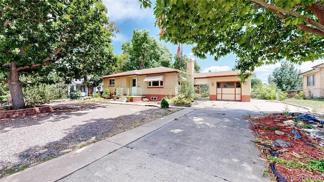 4420 Teller St, Wheat Ridge, CO 80033 - bungalow-style house featuring brick siding, a chimney, and driveway