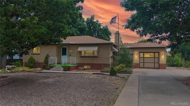 4420 Teller St, Wheat Ridge, CO 80033 - view of front of property with concrete driveway, brick siding, and a garage