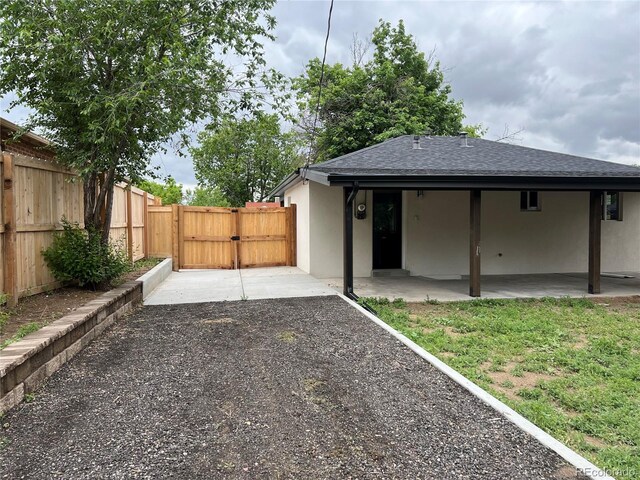 3210 Newport St, Denver, CO 80207 - rear view of house with a gate, roof with shingles, a patio, and stucco siding