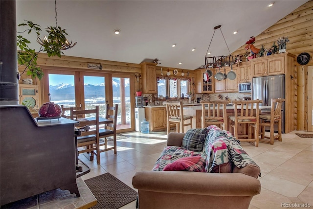 tiled living room featuring a mountain view, a healthy amount of sunlight, and high vaulted ceiling