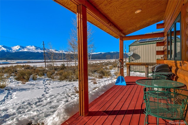 snow covered deck featuring a mountain view