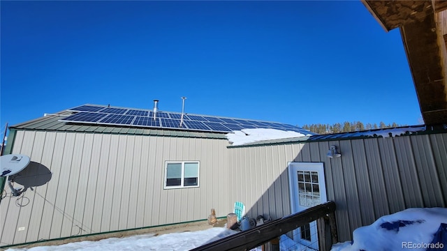 view of snow covered exterior with solar panels