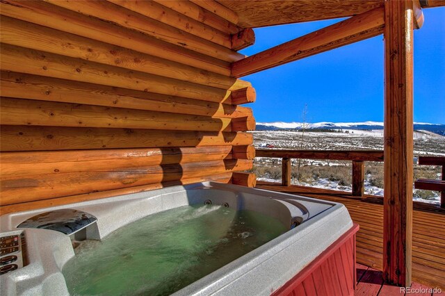 exterior space featuring a mountain view and a hot tub