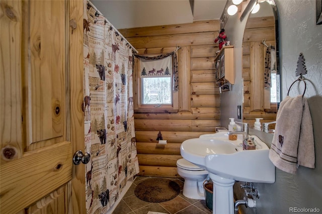 bathroom with tile patterned floors, log walls, and toilet