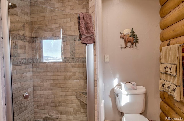 bathroom featuring toilet and tiled shower