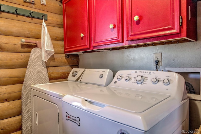 washroom featuring washer and dryer, rustic walls, and cabinets