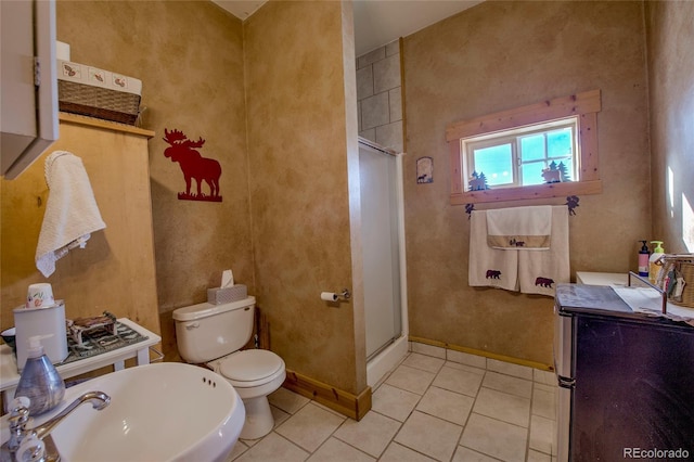 bathroom featuring tile patterned flooring, toilet, a shower with shower door, and sink