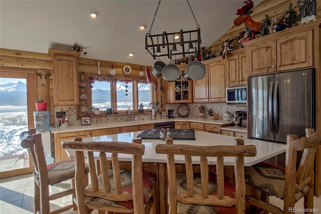 kitchen with sink, a center island, stainless steel appliances, tasteful backsplash, and a mountain view